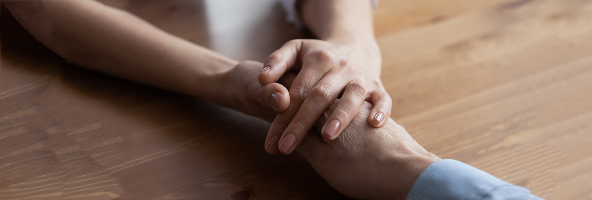 Pension für Witwen bzw. Witwer und hinterbliebene eingetragene Partnerinnen bzw. Partner: Zwei Hände halten sich tröstend
