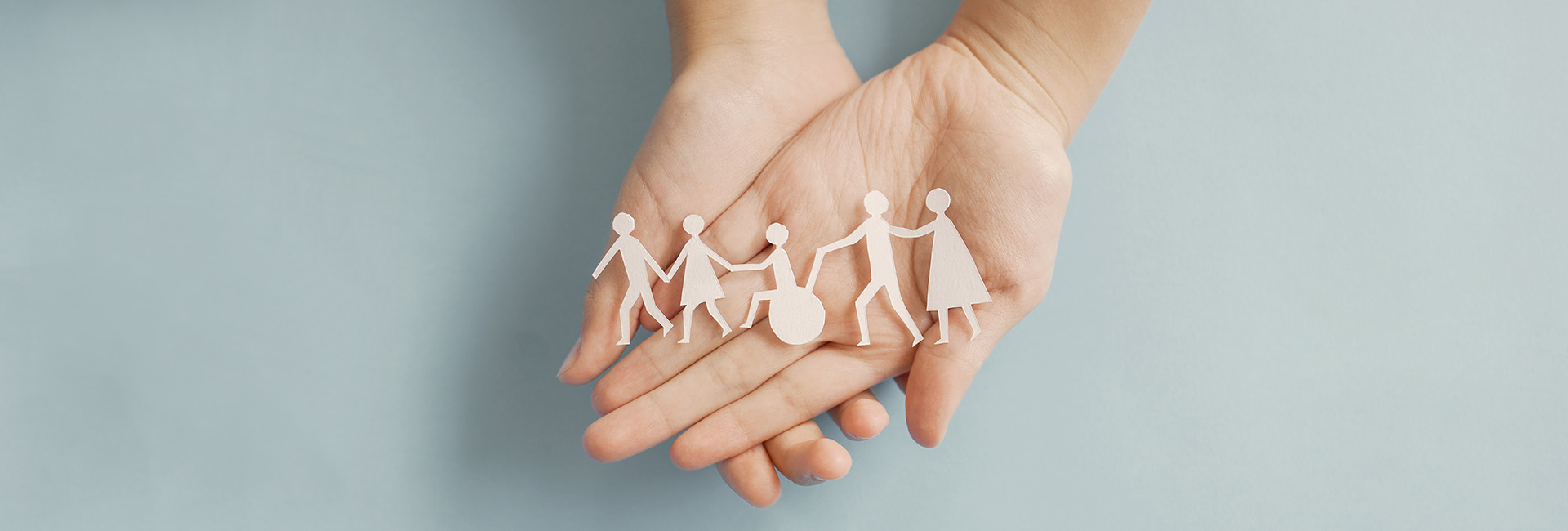 Arten der Pension: Hände halten Papierschnittfiguren die eine inklusive Gemeinschaft darstellen