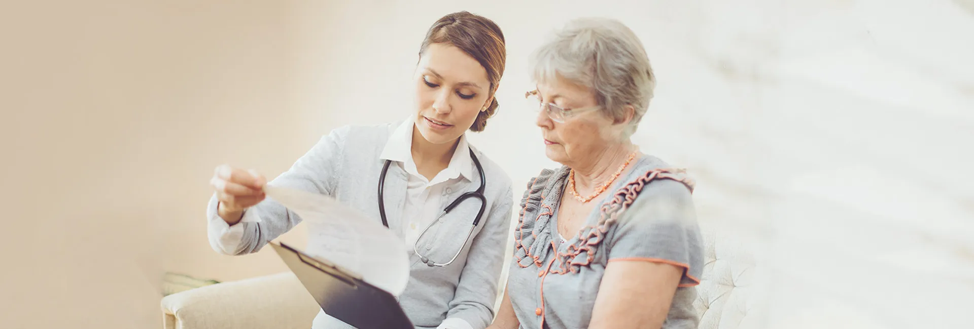 Ärztin erklärt älterer Patientin Ablauf der Begutachtung