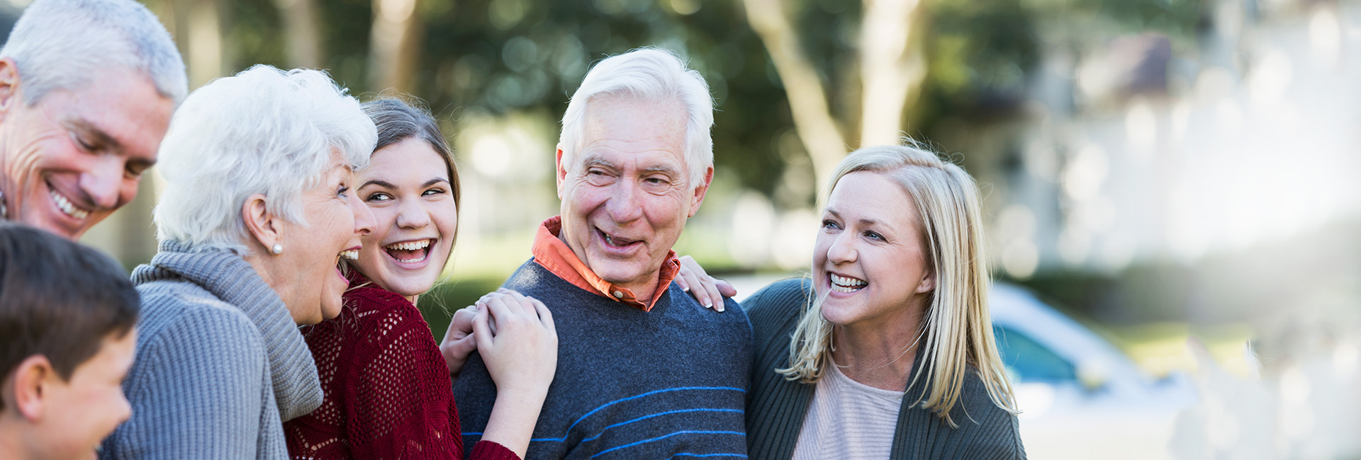 In Pension gehen: Fröhliche Mehrgenerationenfamilie – Großeltern im Mittelpunkt, Eltern und Kinder – lacht zusammen