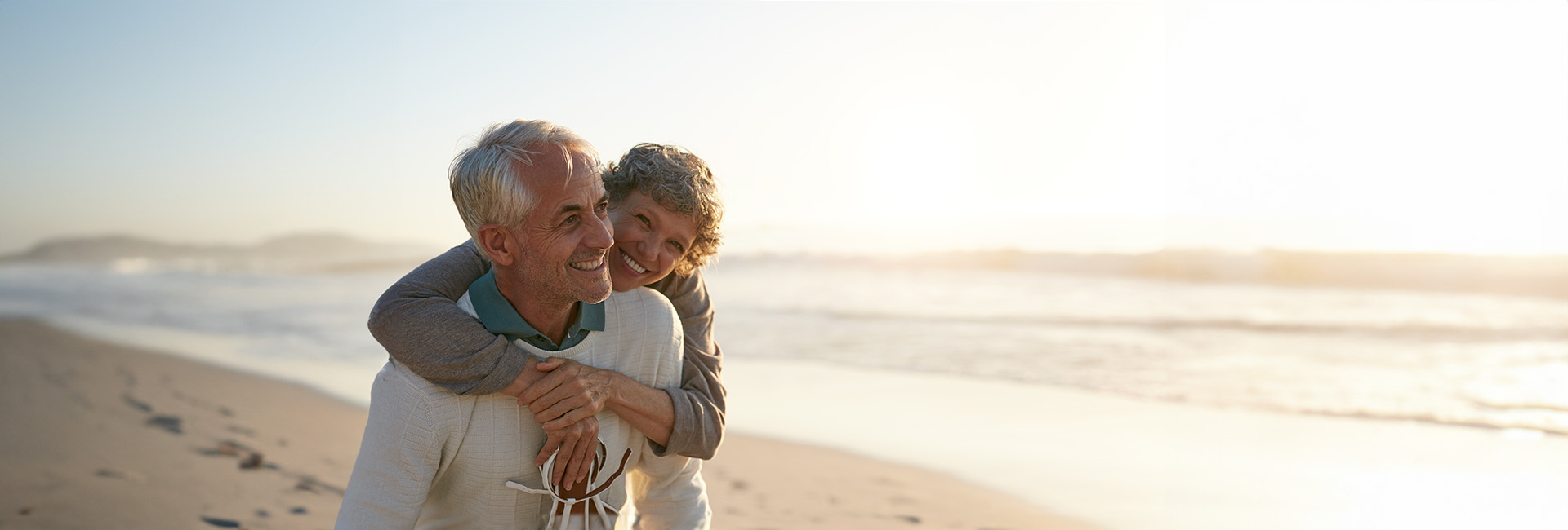 Pension und Ausland: Glückliches älteres Paar am Strand