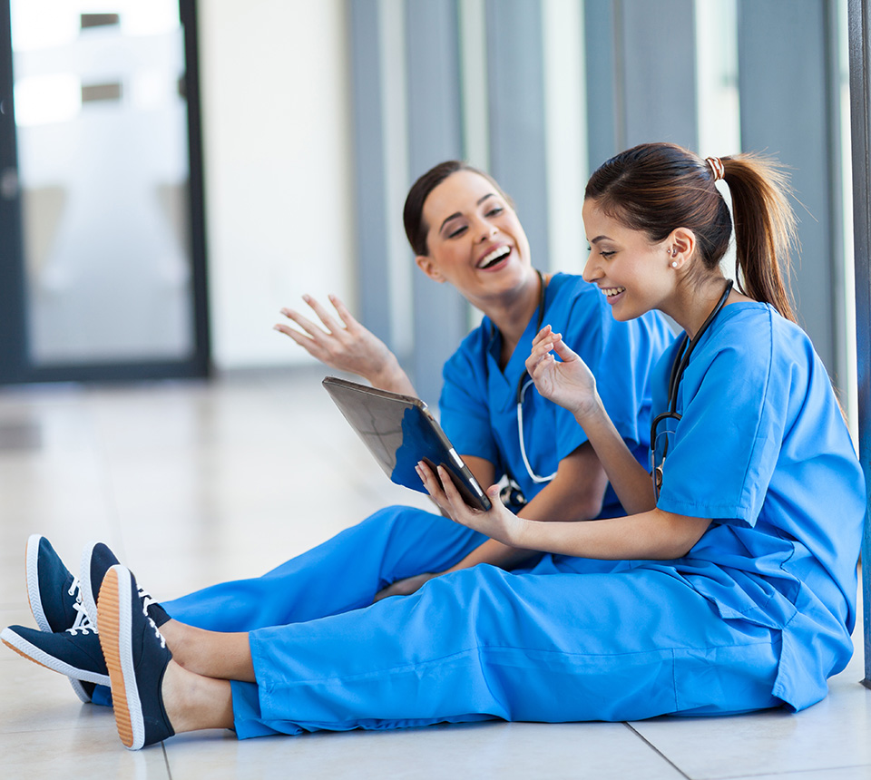 Zwei Pflegerinnen machen Pause und lachen