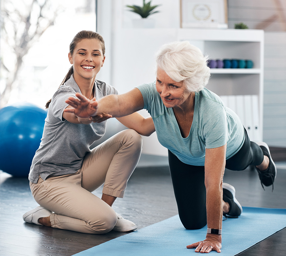 Ältere Frau macht Übung mit Physiotherapeutin