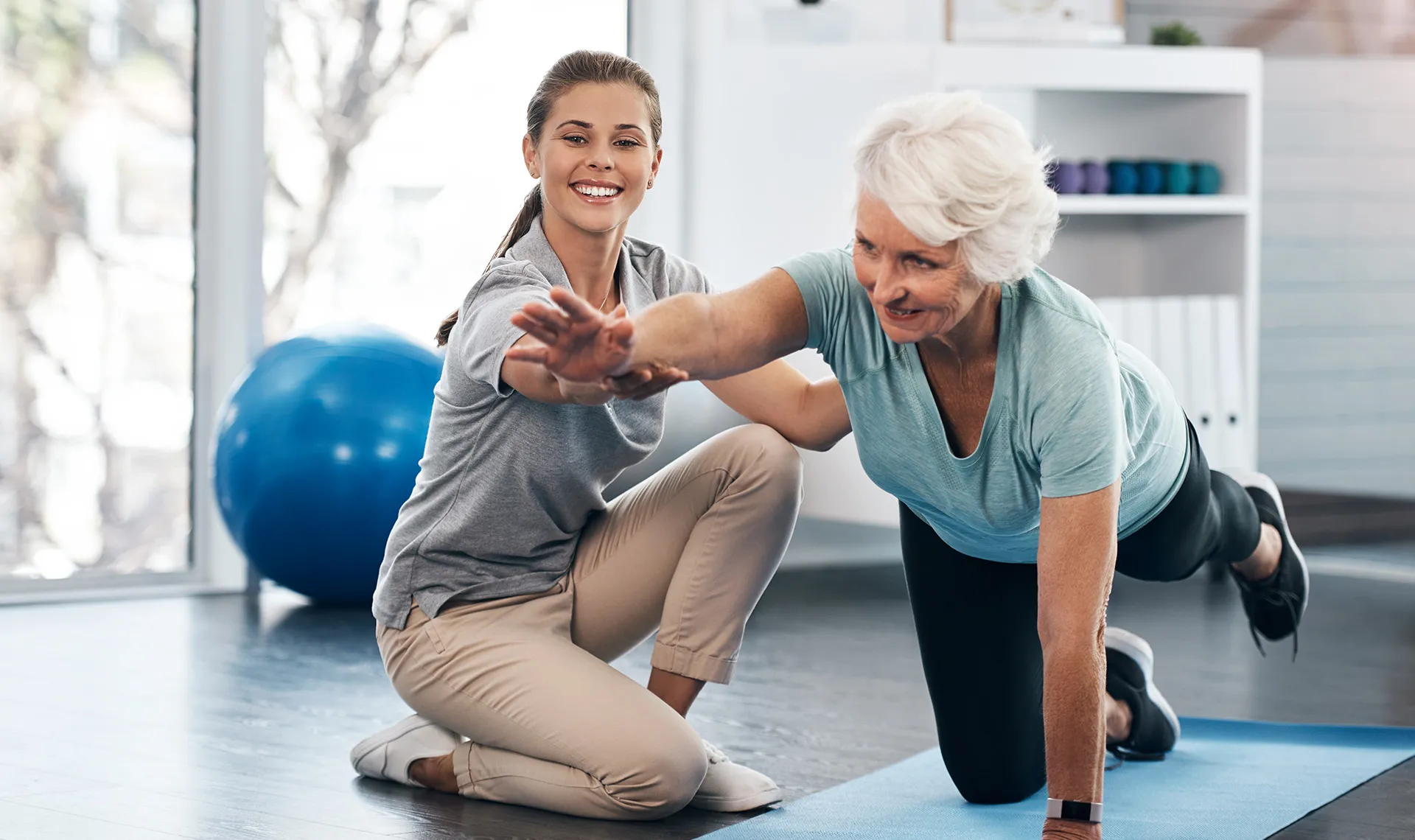 Ältere Frau macht Übung mit Physiotherapeutin