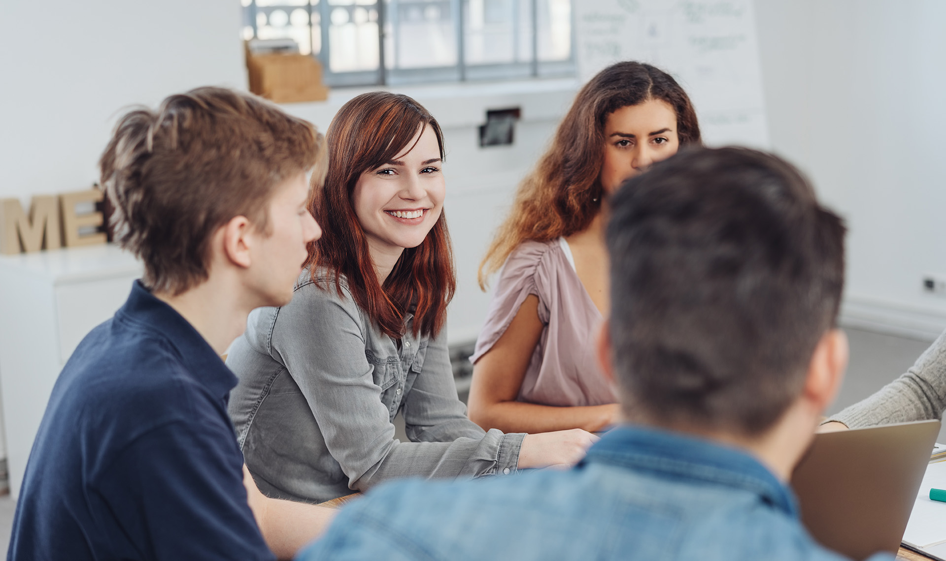 Vier Praktikant*innen sitzen bei einer Besprechung